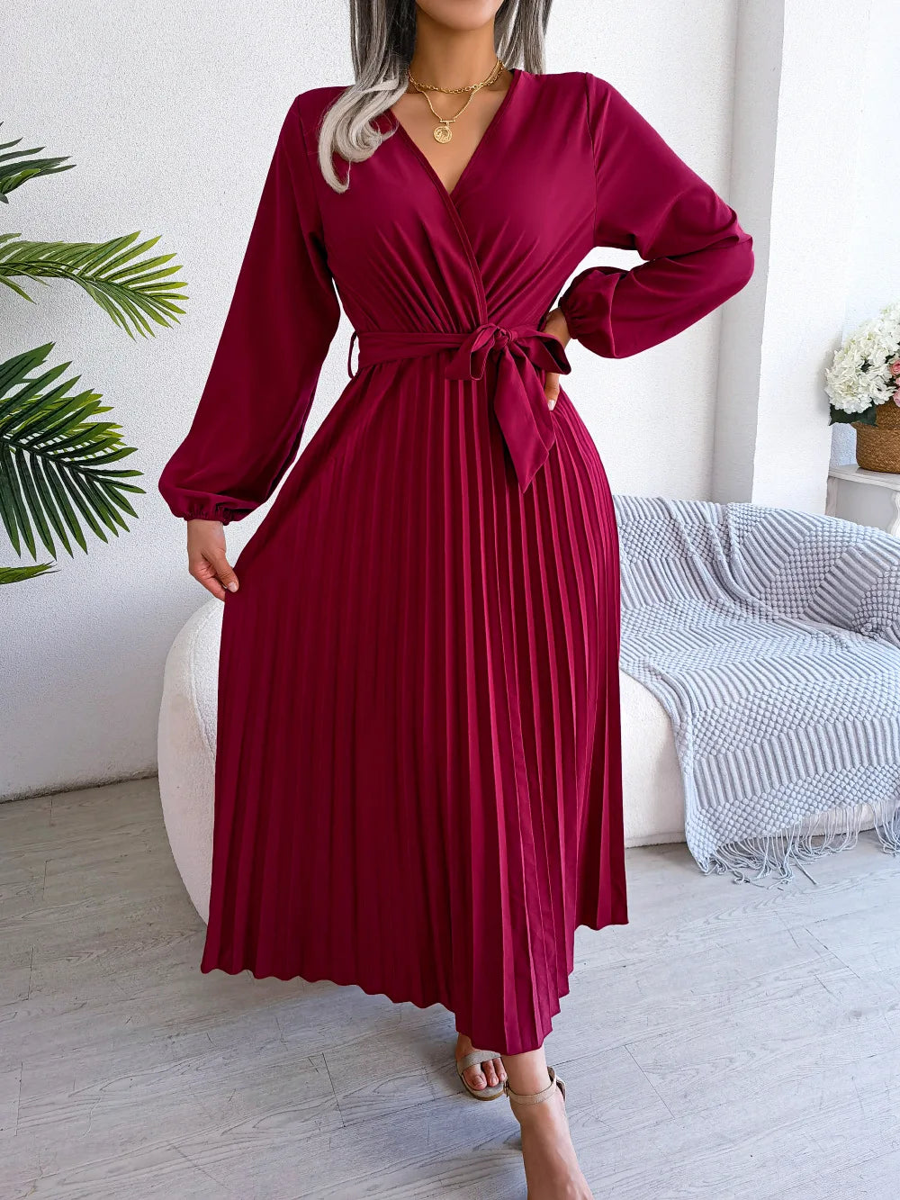 Elegant V-neck pleated maxi dress with long sleeves.